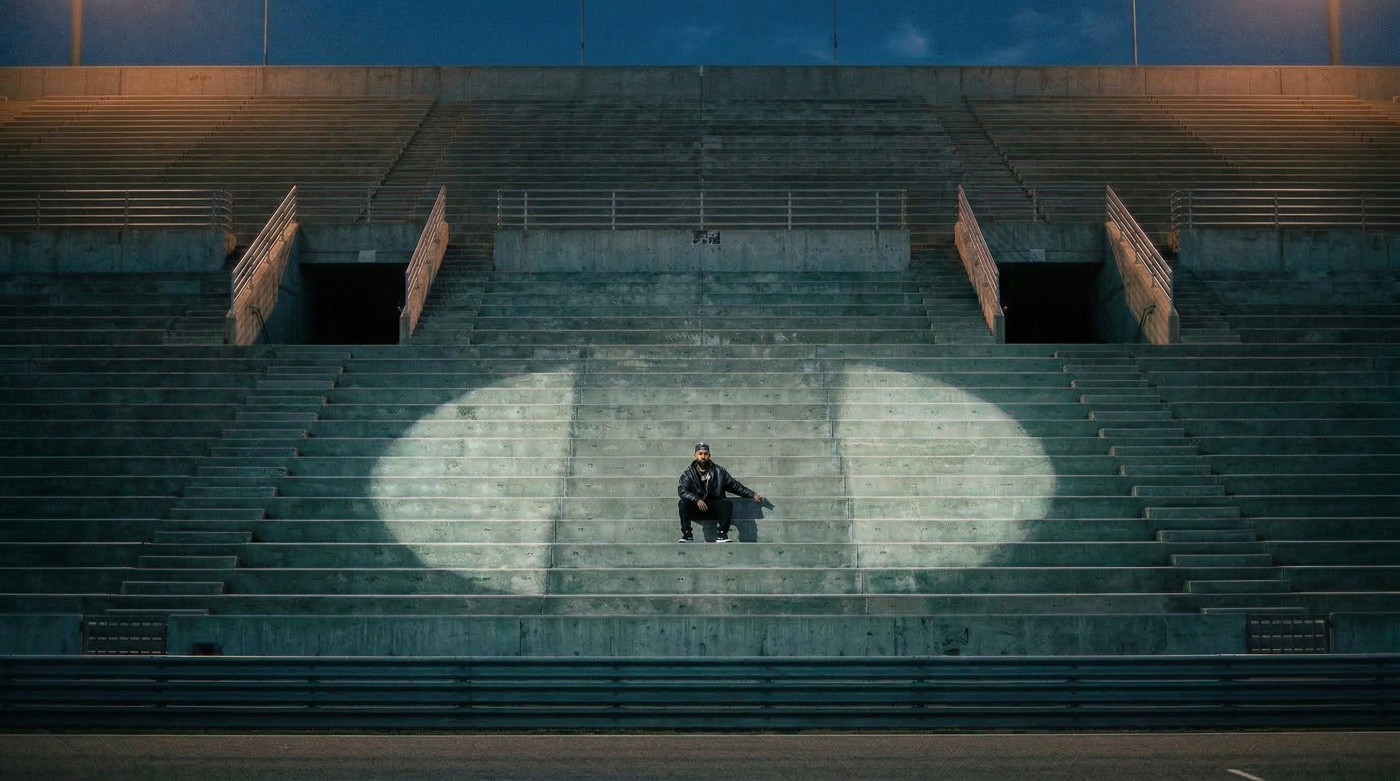 AI visual development of Eladio Carrión in a pool of light on the Corsa grandstand